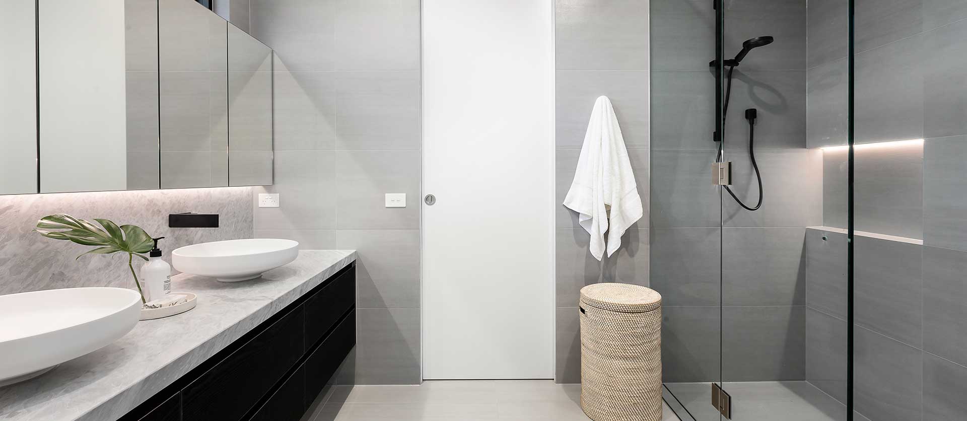 Horizontal view of a new Los Angeles bathroom renovation, featuring Jack-and-Jill sinks and a walk-in shower.